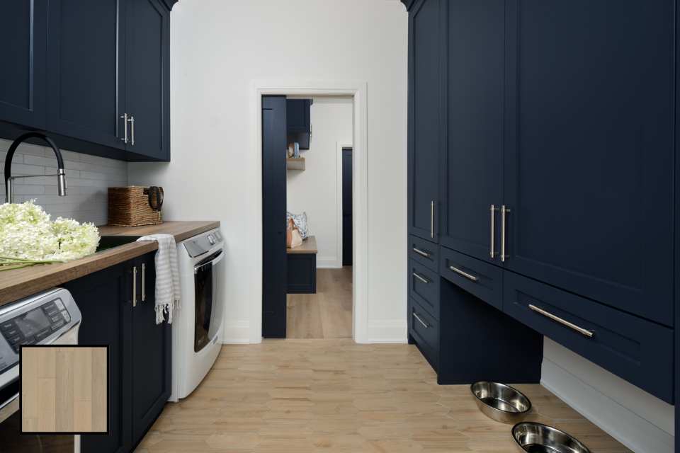 combined laundry mudroom with navy blue cabinets, white oak floors, and sliding pocket door